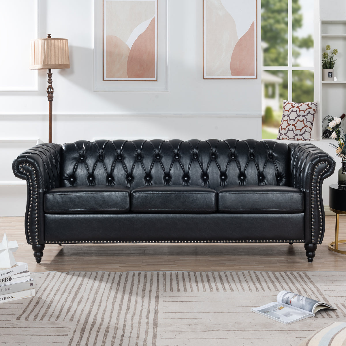 Black faux-leather Chesterfield sofa styled in a living room, front view