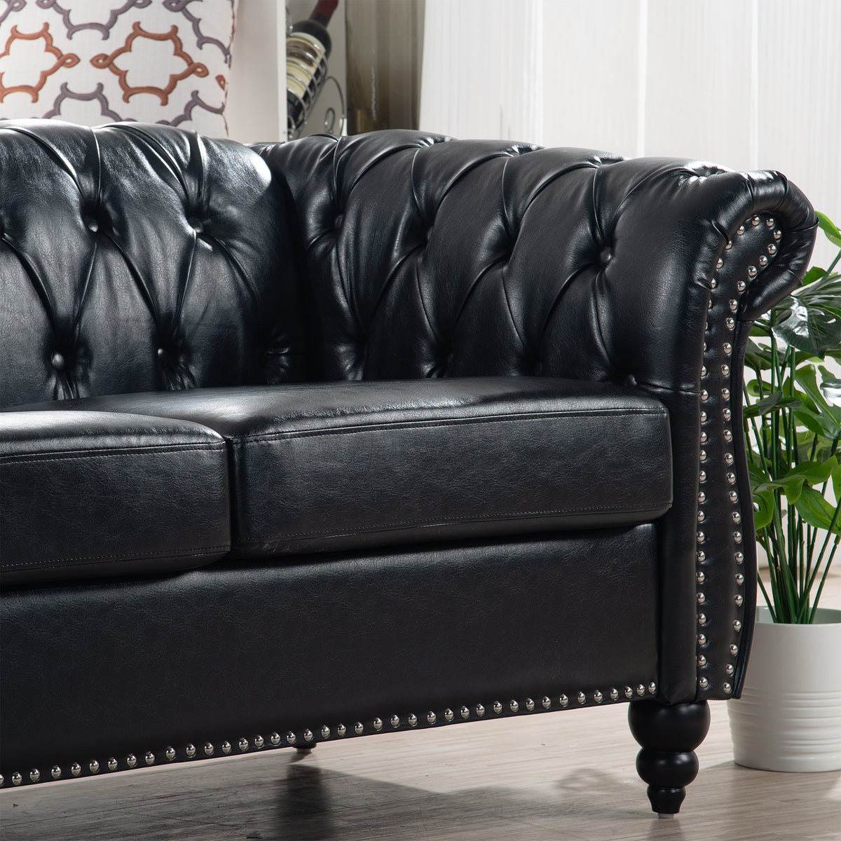 Detail of rolled arm, seat cushion, stud trim and birch leg