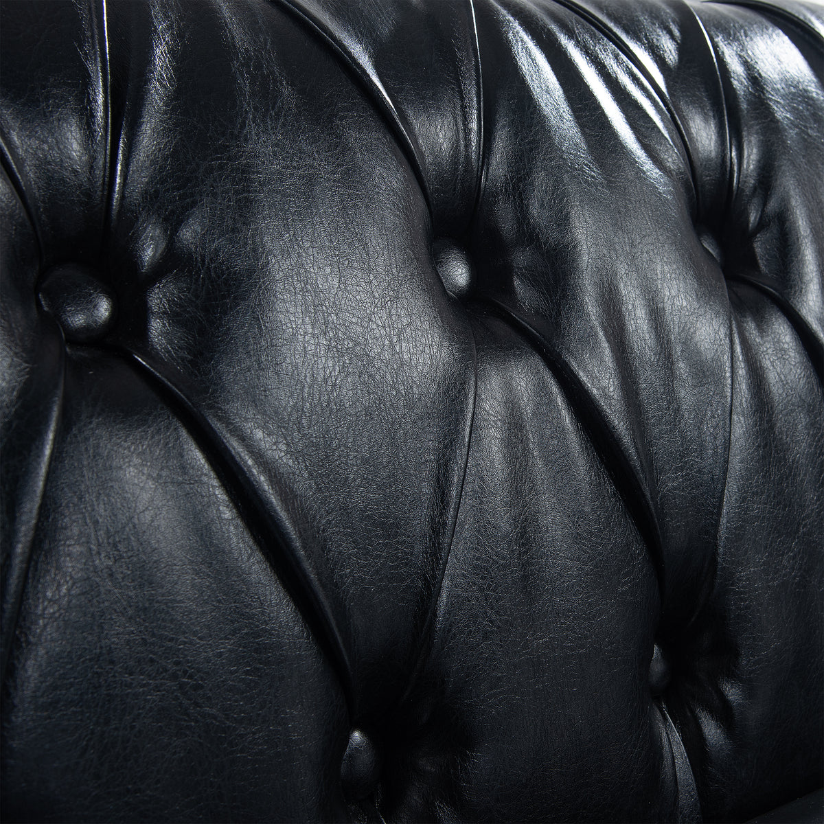 Close-up of the black PU upholstery and button tufting