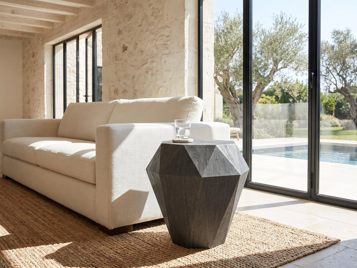 Accadia Grey Mango Faceted Octagon Side Table beside a linen sofa in a poolside villa