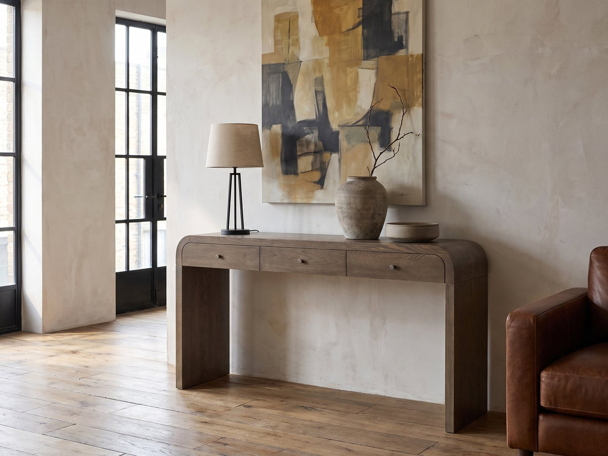 Adelfia Ash Veneer Waterfall Console Table against a plaster wall in an industrial loft