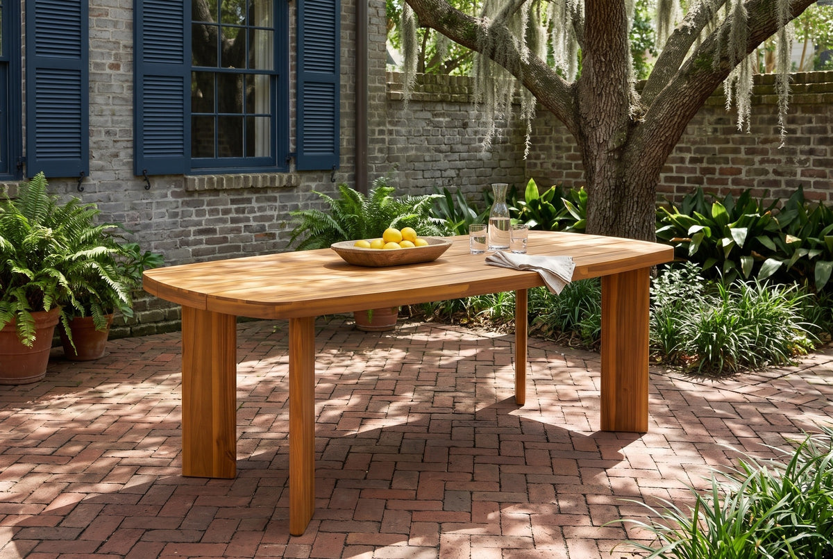 Adrano acacia dining table on a herringbone brick floor in a walled Savannah courtyard, a grey brick wall with blue shutters, ferns in terracotta pots and a live oak with Spanish moss (chairs not included)