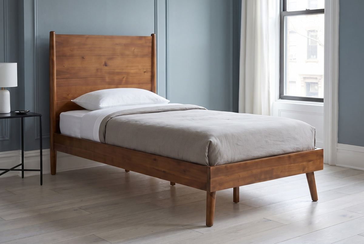Agnone bed against a dusty blue-grey wall in a Brooklyn brownstone bedroom with a tall window and a pale oak floor