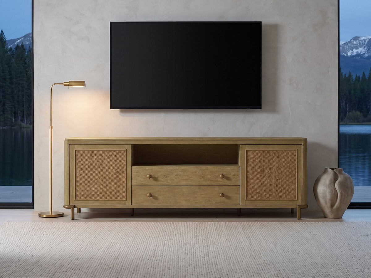Alassio 80-Inch Sand Wash Ash and Rattan Media Console under a wall-mounted screen in a mountain lake house at dusk