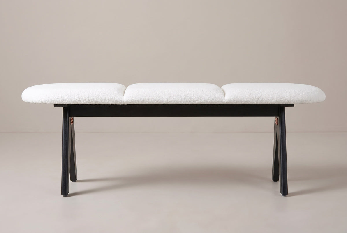 The Alatri bench with a white fabric seat and black legs, side view on a light studio backdrop