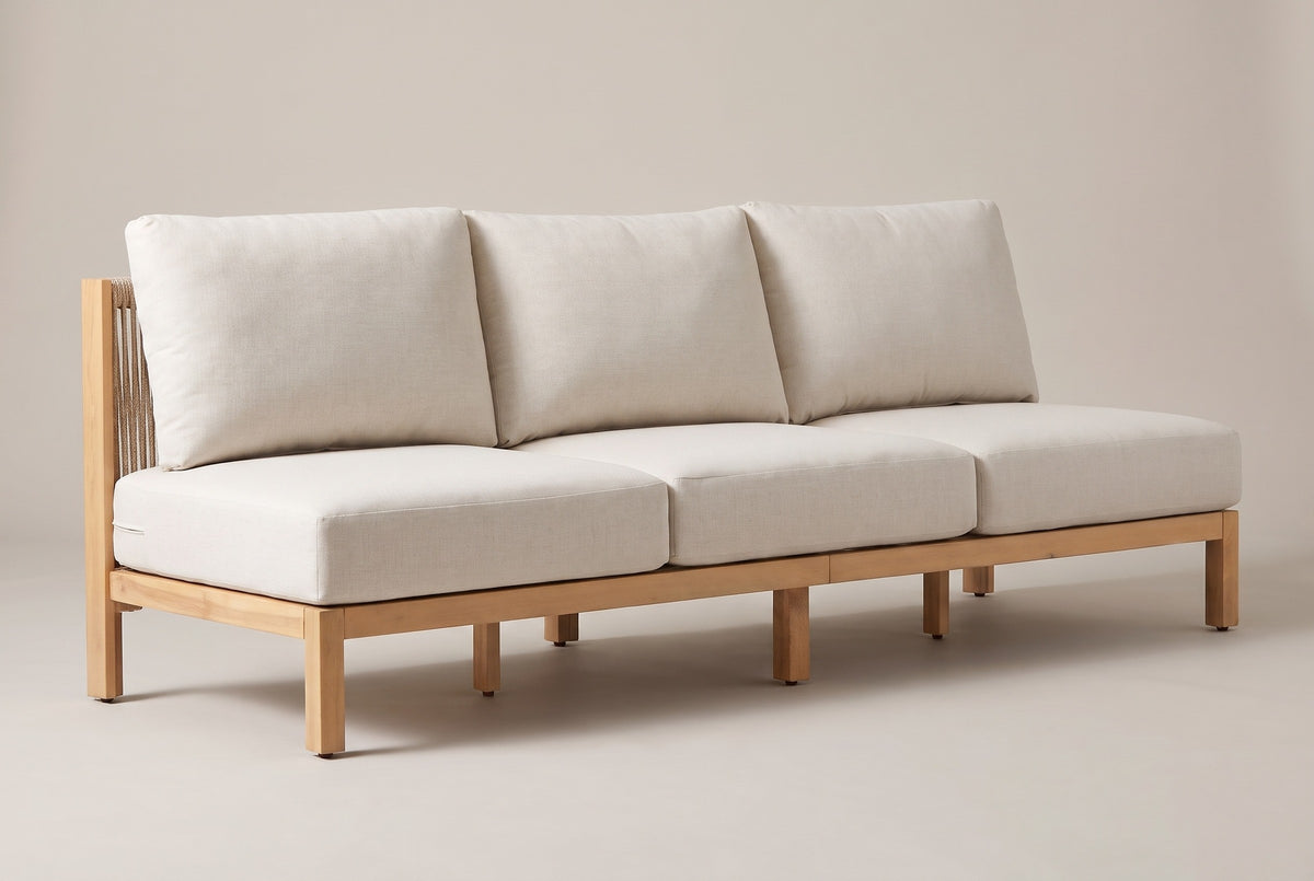 The Alcamo armless acacia outdoor sofa with off-white cushions and a beige rope back, three-quarter view on a light studio backdrop