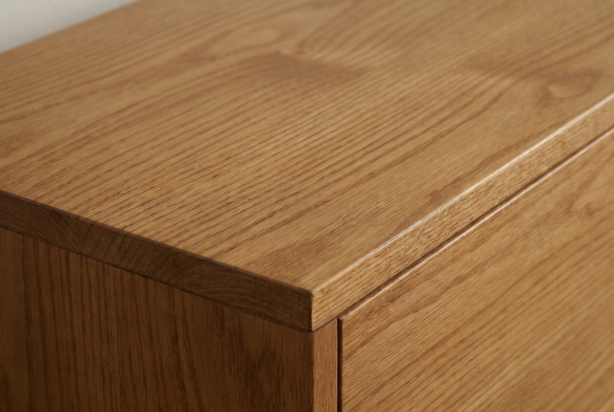 Close-up of the honey-brown wood on the Altamura sideboard: open grain running to a square edge