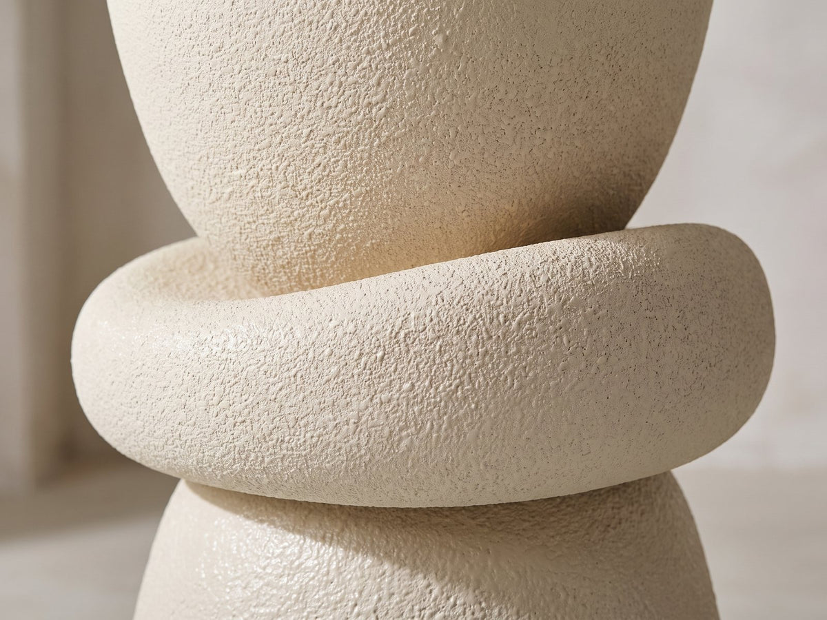 Close-up of the Altomonte Cream Fiberglass Stacked Side Table: the plump ring between the cup and the bell-shaped base