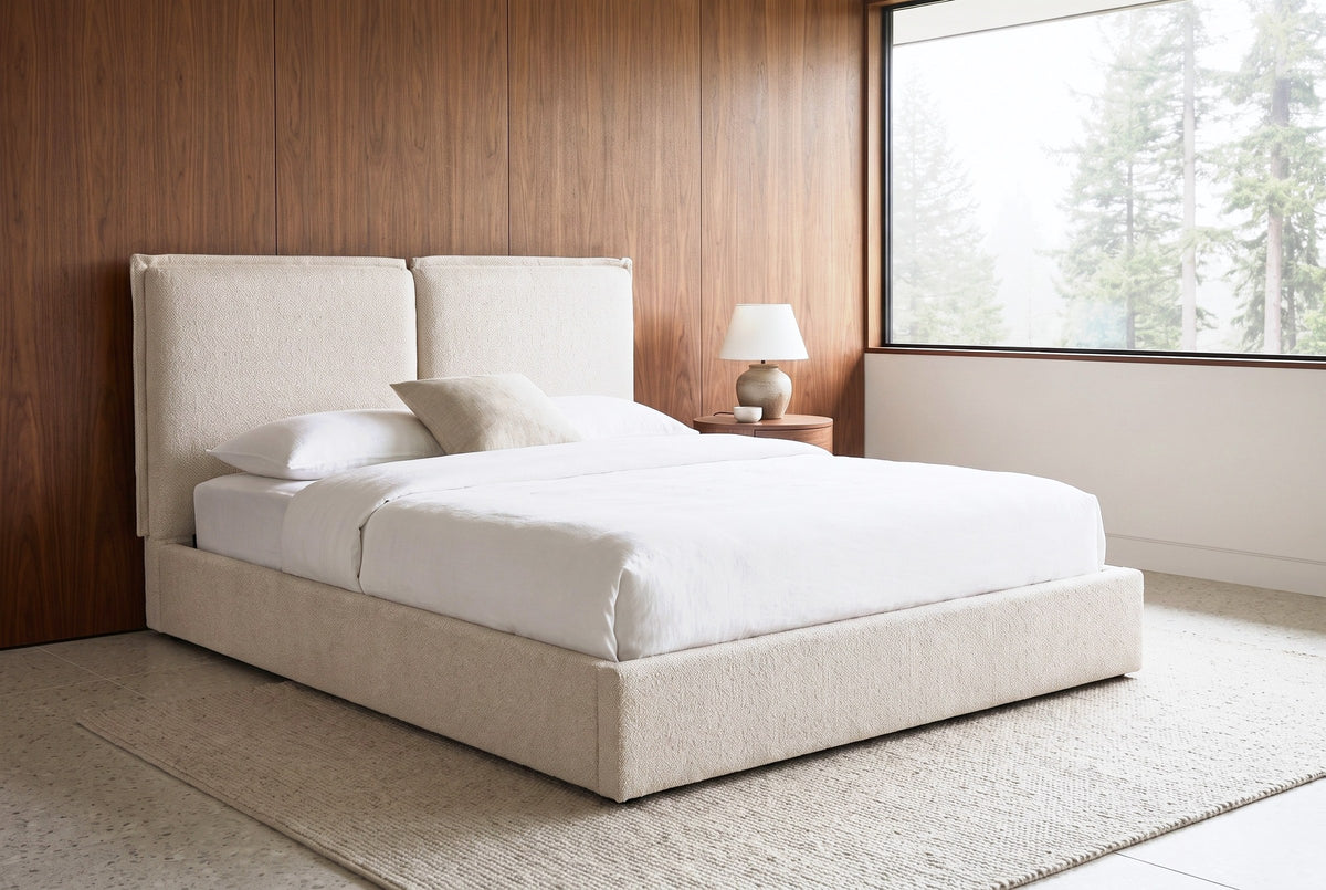 Anversa beige boucle bed against walnut wall panels in a mid-century bedroom near Portland, fir trees in the mist beyond the window