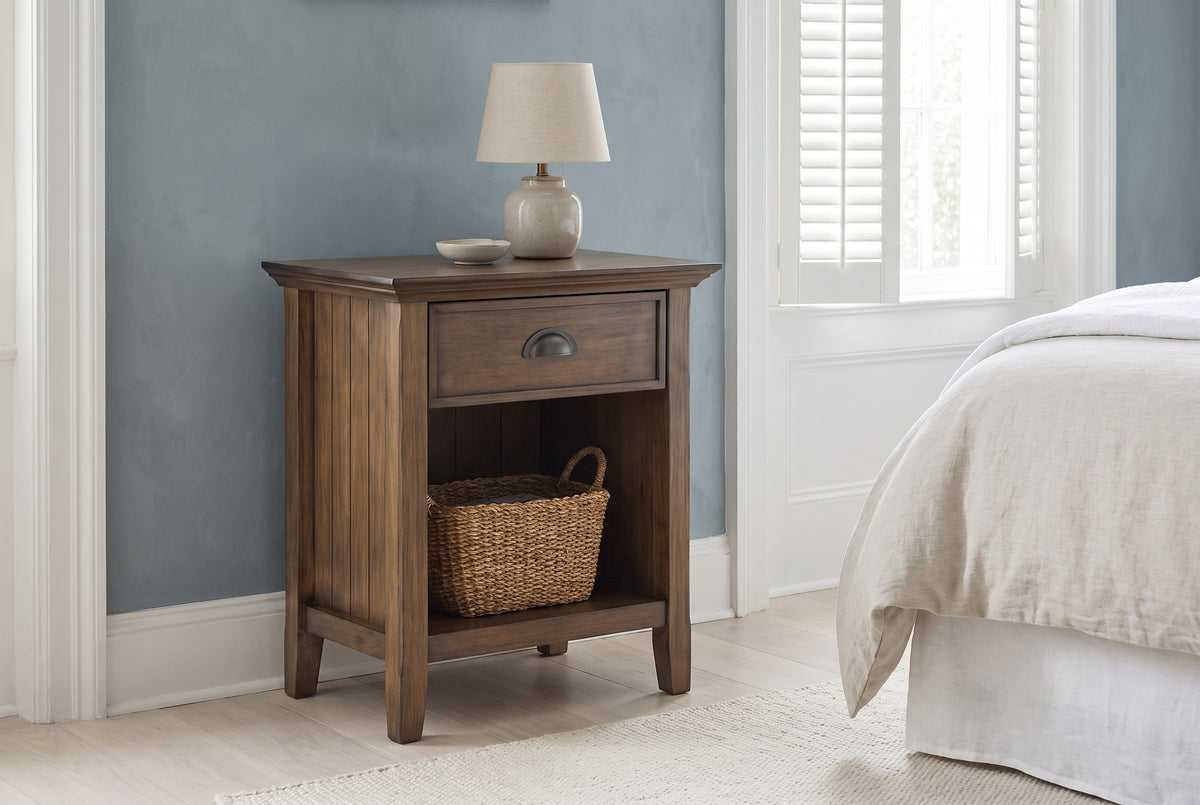 Arbus aged brown nightstand against a dusty blue plaster wall in a Charleston townhouse bedroom with white shutters