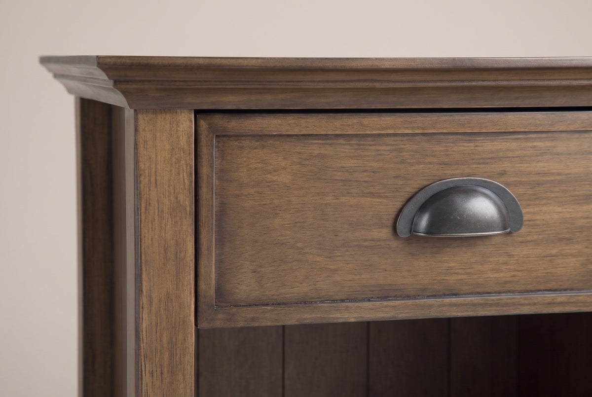 The drawer of the Arbus nightstand: a framed drawer front in aged brown with an antique-finish metal cup pull, the crown moulding above