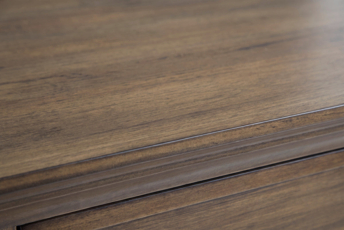Close-up of the rustic aged brown wood on the Arbus nightstand: straight grain with darker streaks running to the crown moulding