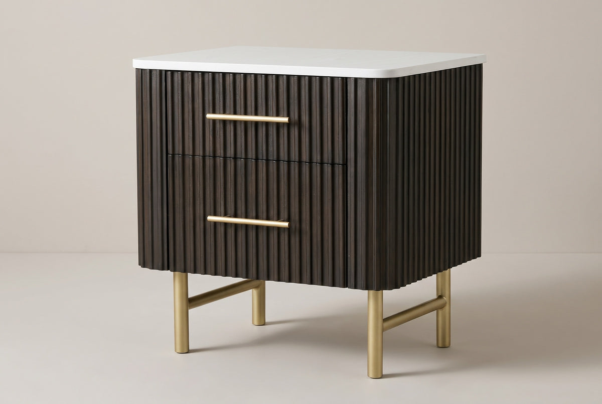 The Aritzo two-drawer nightstand in espresso with wide vertical reeds, a white engineered-stone top, gold bar pulls and gold legs, three-quarter view on a light studio backdrop