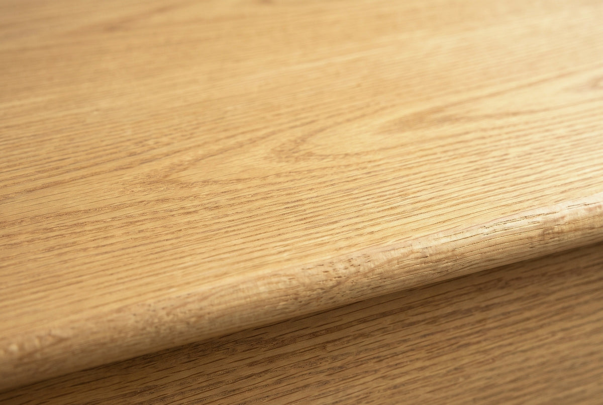 Close-up of the wire-brushed white oak veneer on the Arzachena nightstand: open pores and soft arches running to a rounded edge