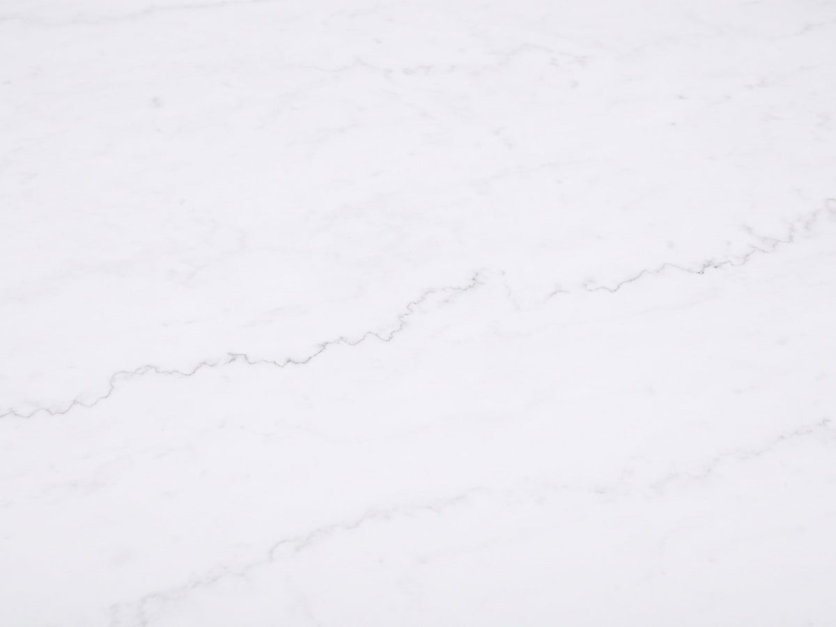 Close-up of the Asti 40-Inch Round White Marble Coffee and End Table Set, 3 Pieces: the fine grey veins of the white marble top