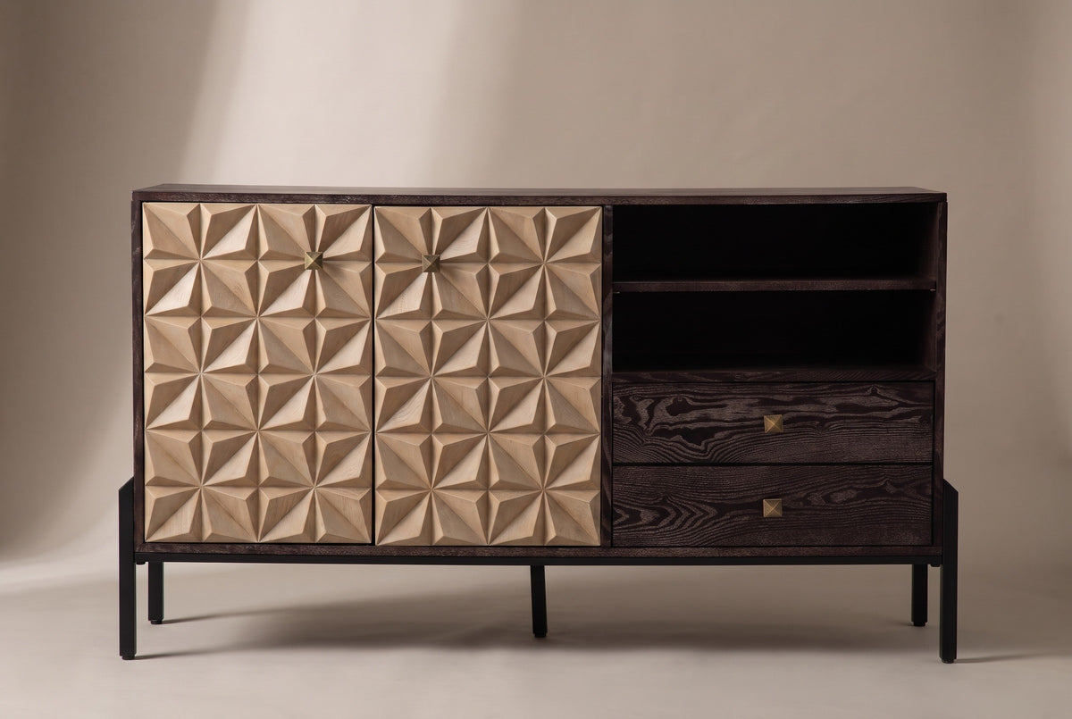 The Atella sideboard, front view on a light studio backdrop: two carved doors, two open cubbies, two drawers and a black metal base