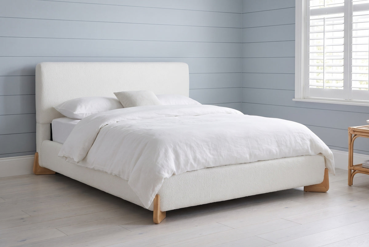 Atessa white boucle bed in a Hamptons cottage bedroom with blue-grey shiplap walls and whitewashed oak floors