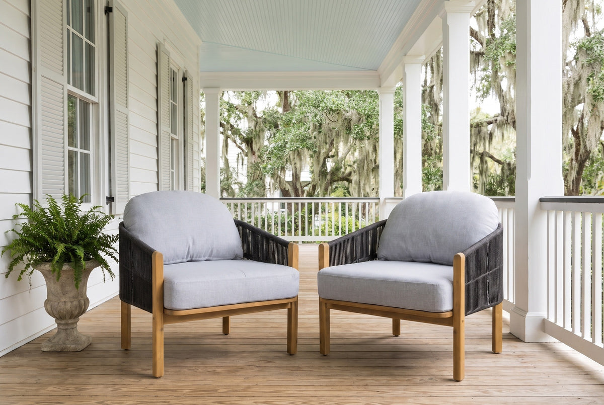 Two Avola club chairs on a Lowcountry porch in Beaufort, white clapboard and shutters, a haint-blue ceiling, heart-pine floor and live oaks with Spanish moss