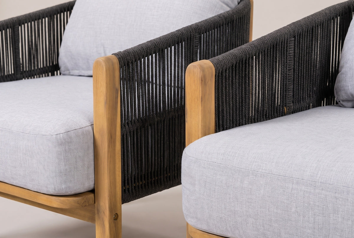 Close-up of the Avola chairs: dark gray rope strands, a square acacia front post with a teak finish and the light gray cushion fabric