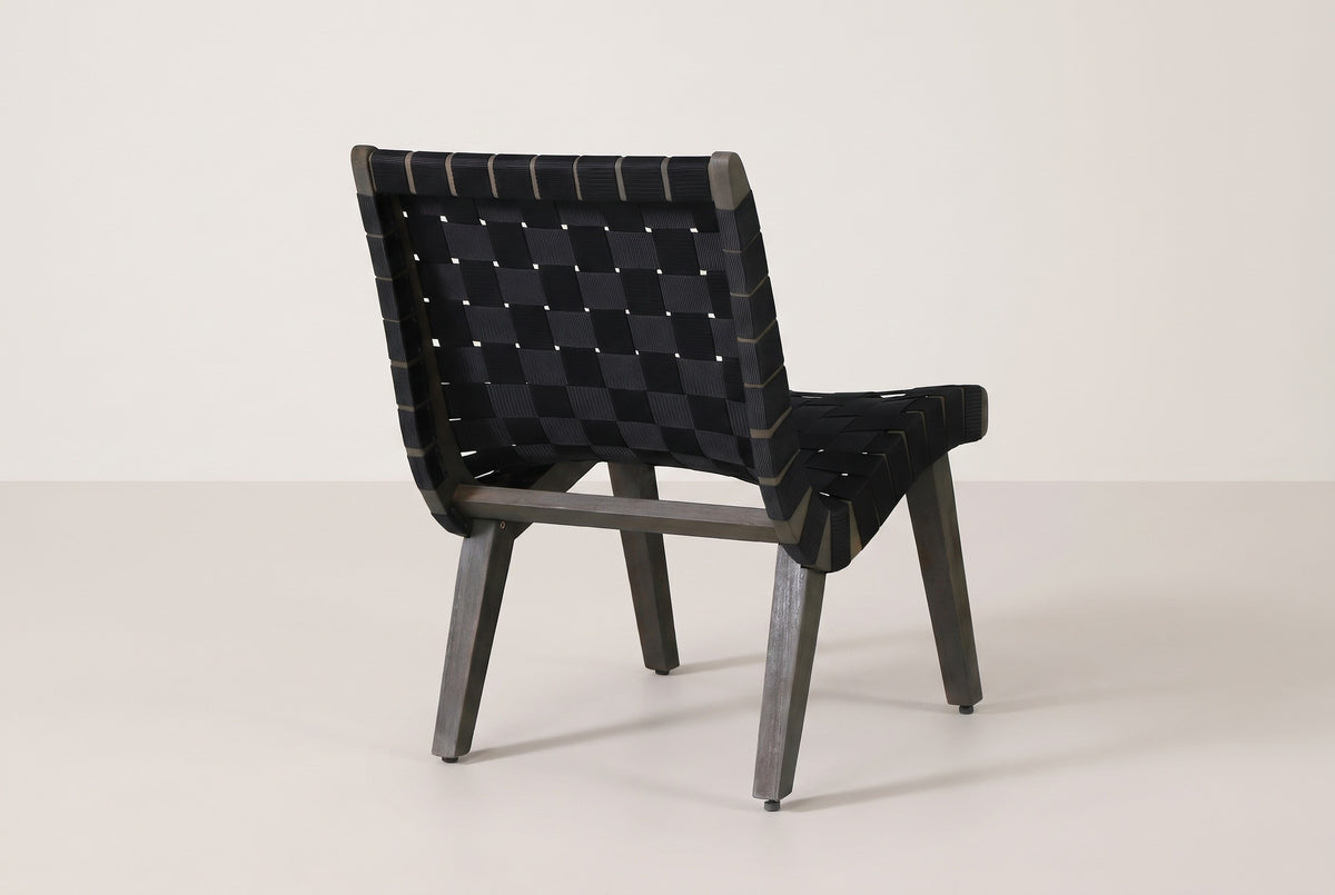 One Bagheria chair seen from behind: the woven back, the strap ends wrapped round the side rails, four splayed legs and the back stretcher