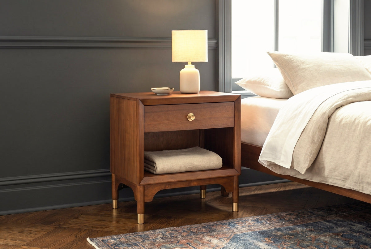 Berchidda nightstand against charcoal wall panelling in a New York apartment bedroom, a herringbone floor and a faded blue rug