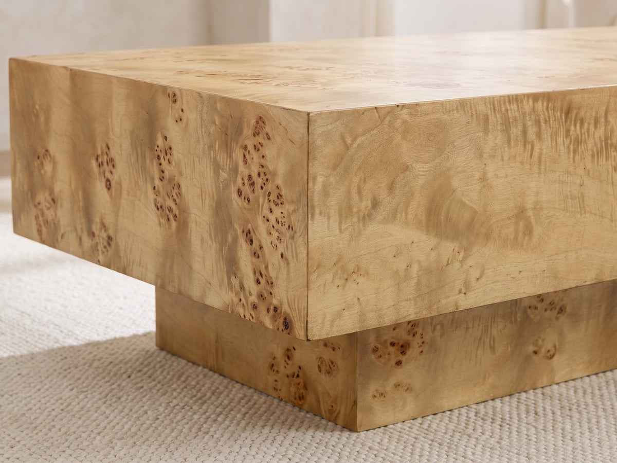 Close-up of the Biella 43-Inch Rectangular Burl Wood Veneer Coffee Table: the corner of the burl top block overhanging the recessed base