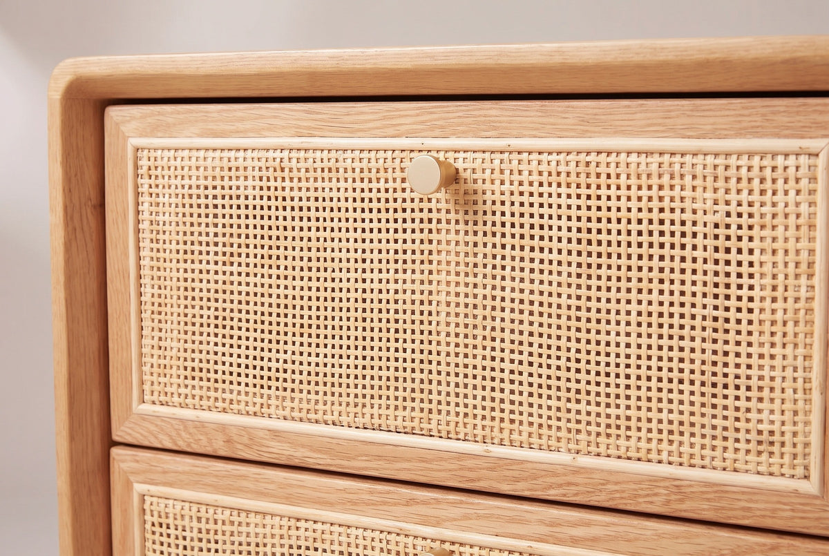 The top drawer of the Bono nightstand: woven cane in a slim oak frame with a small round gold knob at the top centre