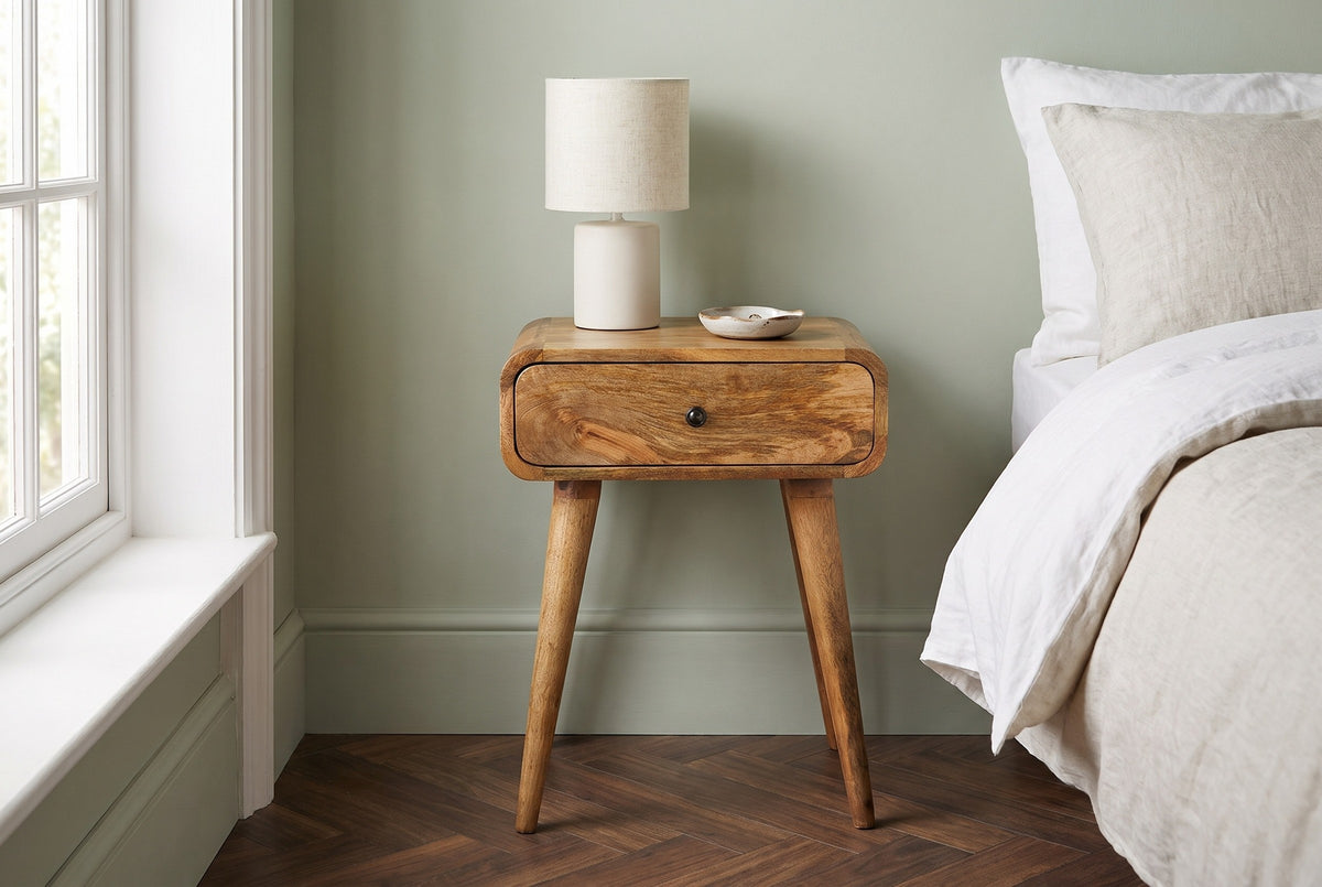 Bonorva light mango nightstand with a ceramic lamp in a Brooklyn brownstone bedroom with a sage-green wall and herringbone floors
