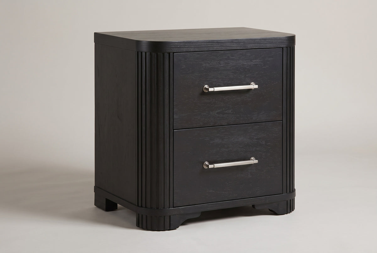The Bosa two-drawer nightstand in charcoal oak with reeded rounded corners and metal bar pulls, three-quarter view on a light studio backdrop