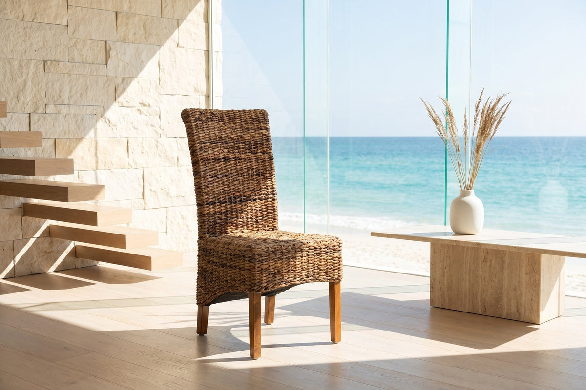 Briatico High-Back Woven Natural Fiber Dining Chair in an oceanfront glass house