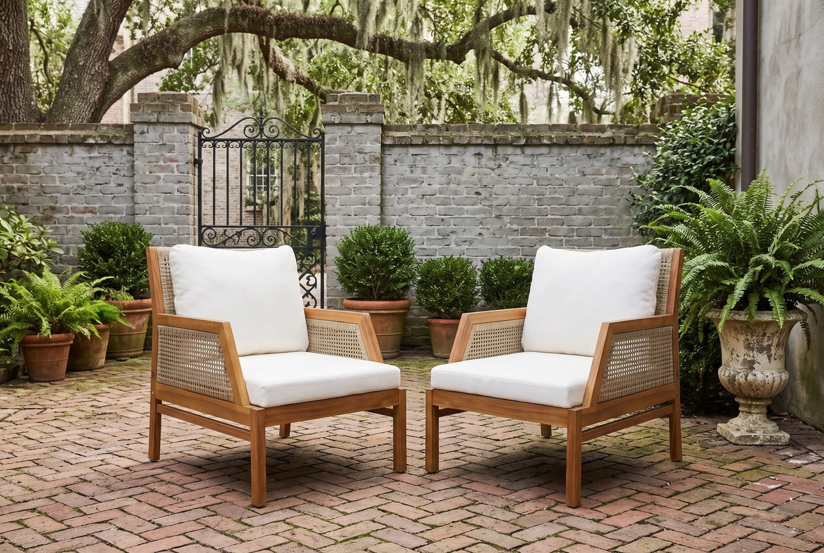 Two Buccheri club chairs in a Savannah courtyard with an old gray brick wall, a wrought-iron gate, herringbone brick paving and a live oak with Spanish moss