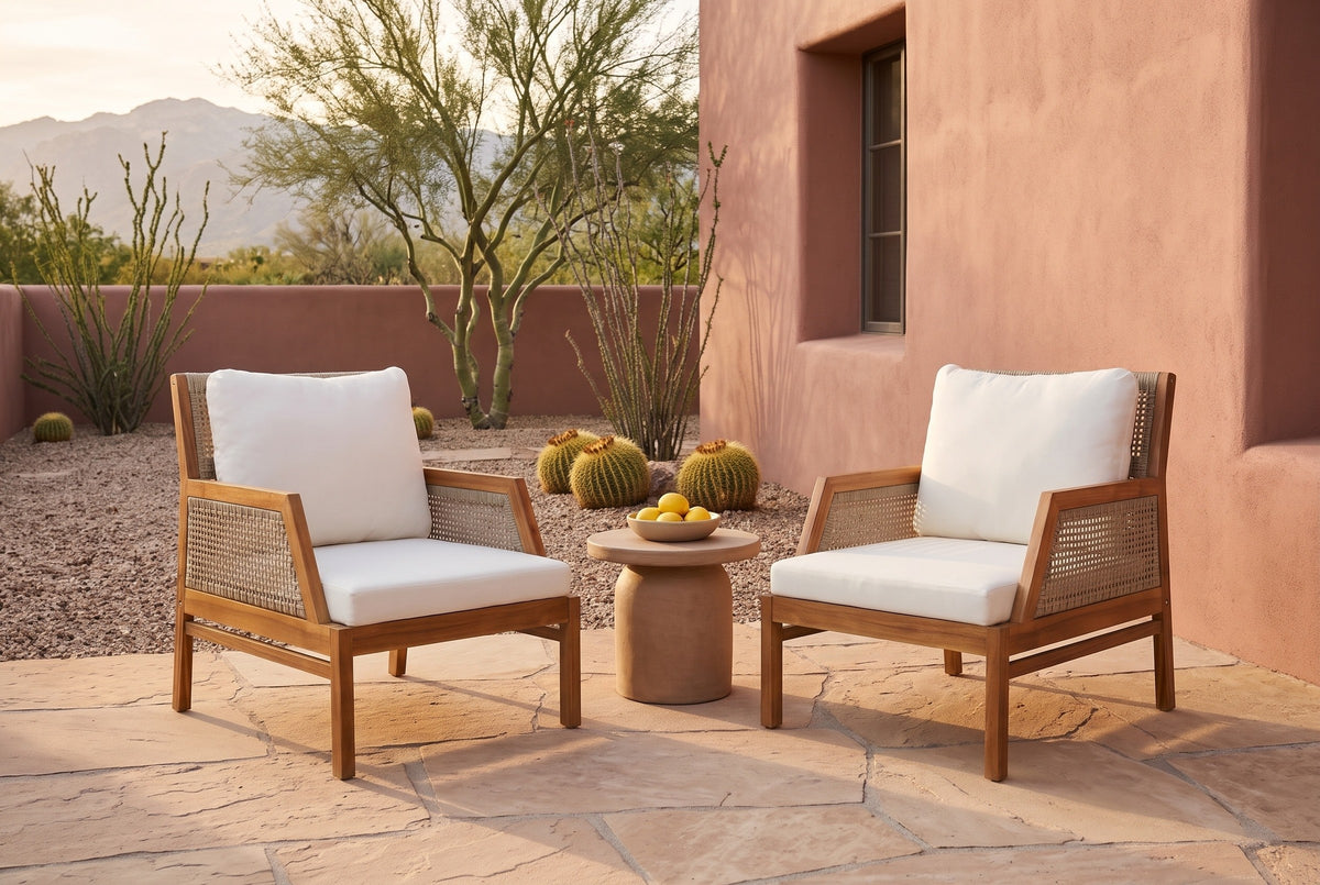 Two Buccheri club chairs on a sandstone flagstone patio in Tucson at golden hour, a rose adobe wall, palo verde, ocotillo and barrel cacti behind (side table not included)