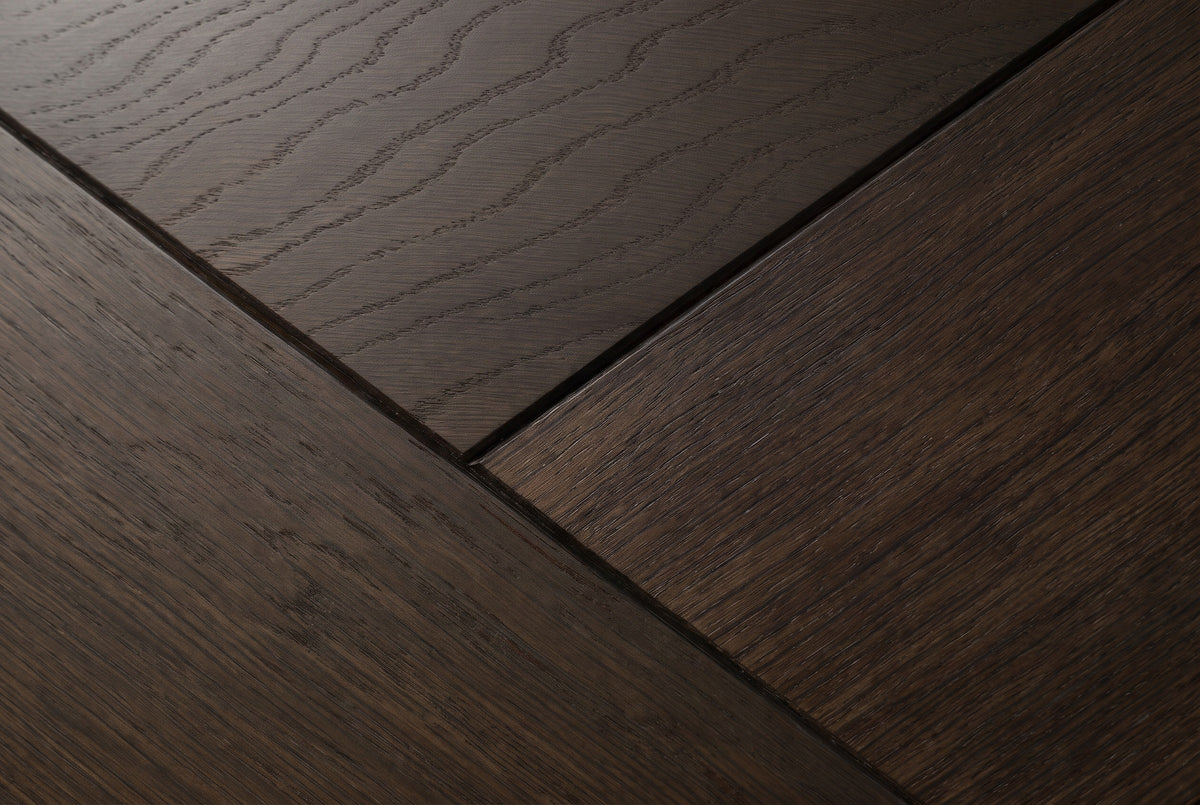 Close-up of the Budoni nightstand: smoked brown oak veneer in angled pieces separated by fine dark grooves