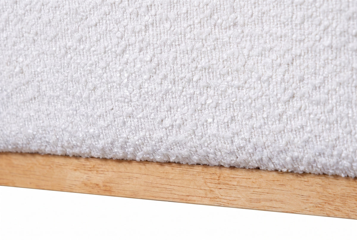 Close-up of the Bussi bed where the white boucle base meets the light rubberwood plinth