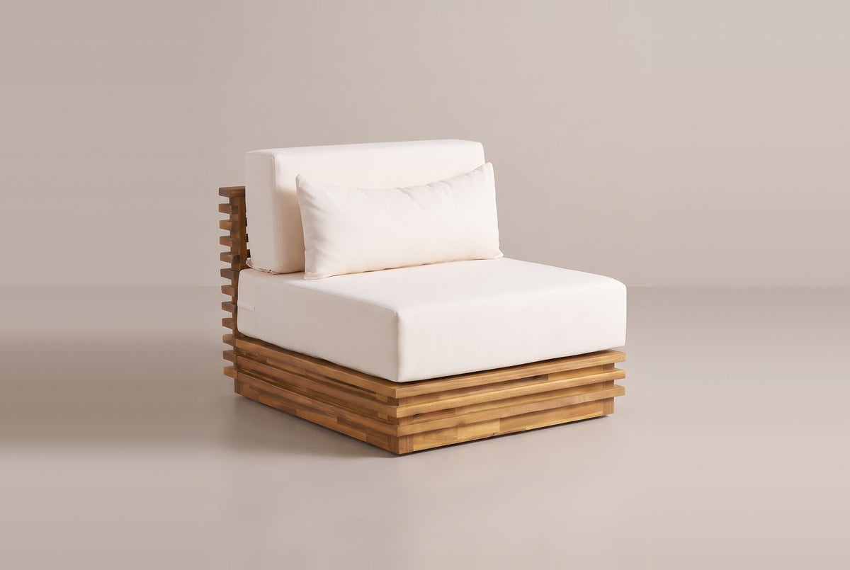 One Calamosche club chair on its own: the layered acacia base, the slatted back panel and the ivory seat cushion, back cushion and lumbar pillow