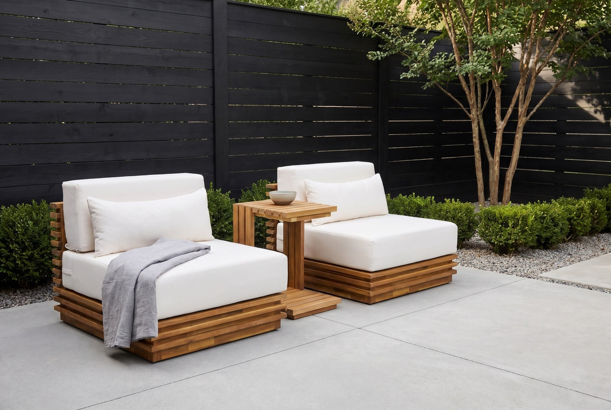 Calamosche acacia chat set in a Dallas courtyard, a charcoal horizontal board fence, a pale concrete floor and a crape myrtle behind