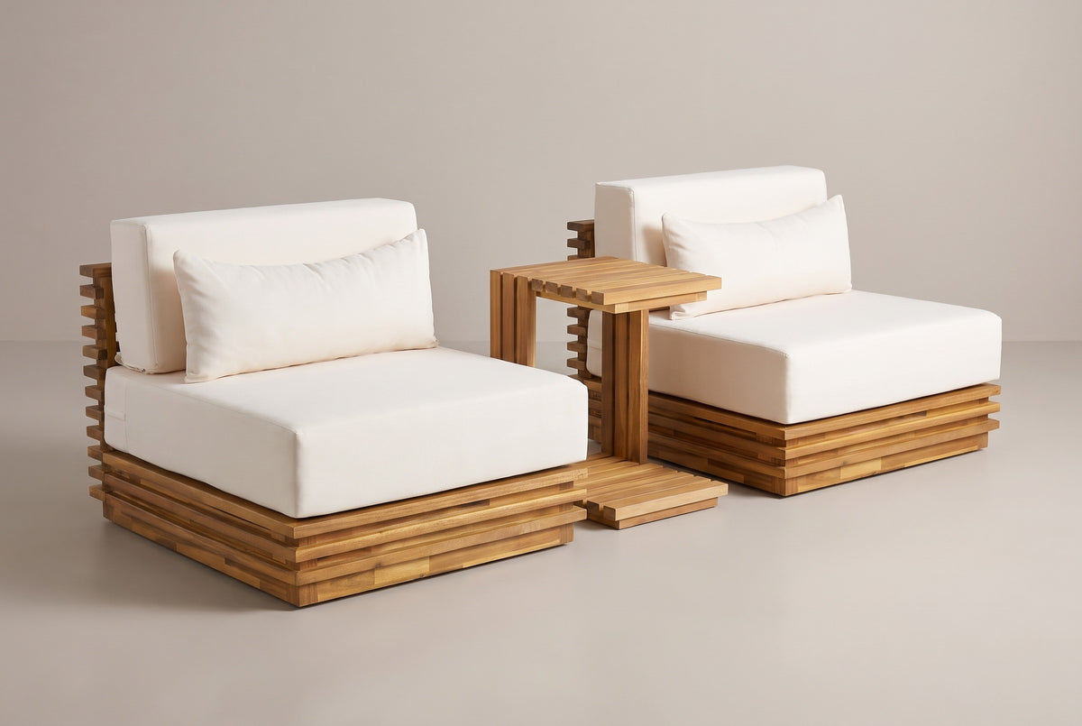 The Calamosche 3-piece chat set: two armless acacia club chairs with ivory cushions and a C-shaped slatted side table between them, on a light studio backdrop