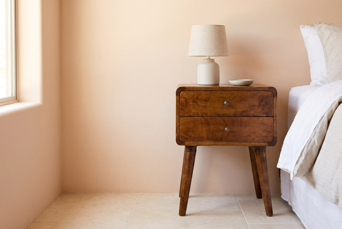 Calasetta chestnut mango nightstand against a soft peach plaster wall in a Scottsdale bedroom with limestone floor tiles