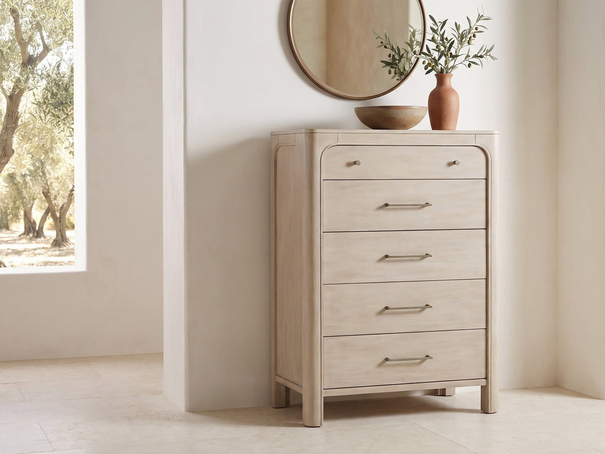 Caorle 38-Inch Weathered Mango 5-Drawer Chest under a round bronze mirror in a villa bedroom