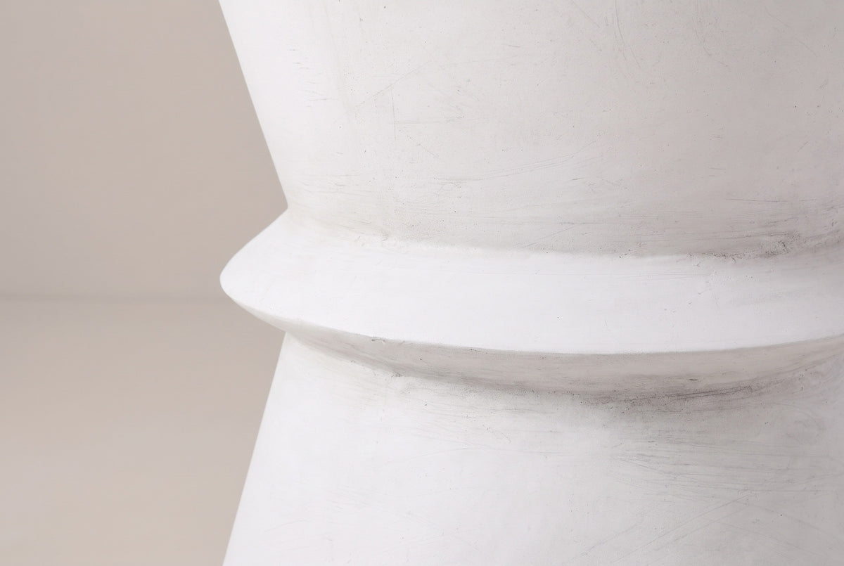 Close-up of the antique white lightweight concrete on the Capizzi side table, with faint brush marks around the waist ring