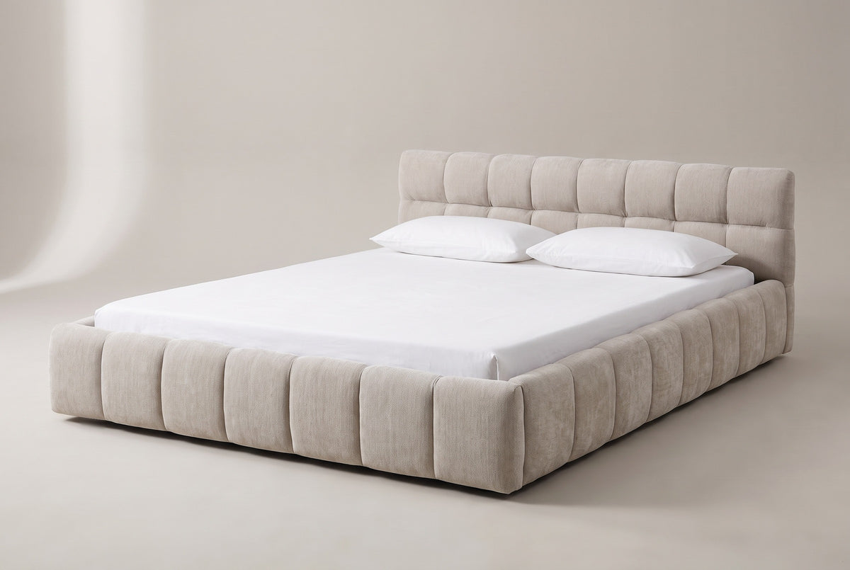 The Capracotta floor bed in beige chenille with a white mattress and pillows (not included), three-quarter view on a light studio backdrop
