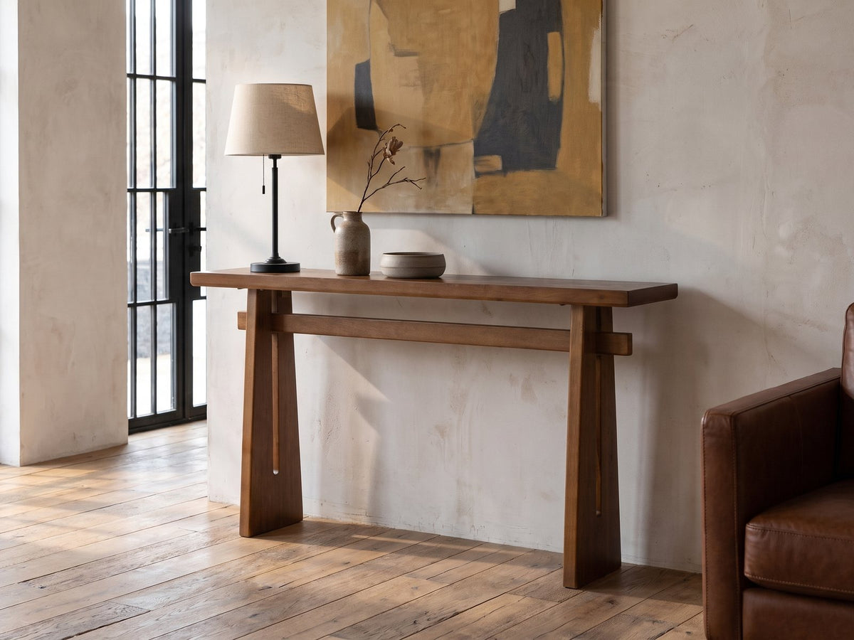 Capurso Wood Veneer Trestle Console Table against a plaster wall in an industrial loft