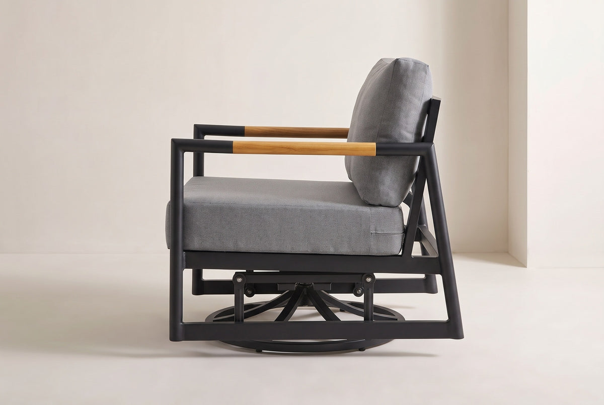 The Carini swivel glider lounge chair from the side: the open black side frame, the teak arm sleeves, two glider links and the round swivel base