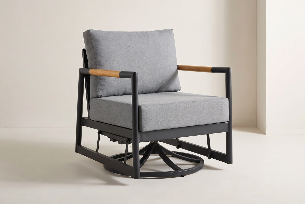 The Carini swivel glider lounge chair in black aluminum with teak arm sleeves and gray cushions, three-quarter view on a light studio backdrop