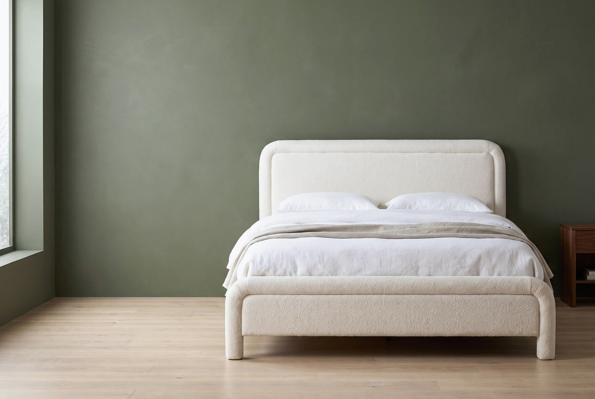 Casacalenda white boucle bed against a deep olive-sage green wall in a Seattle craftsman bedroom, a tall window at the left and a pale oak floor