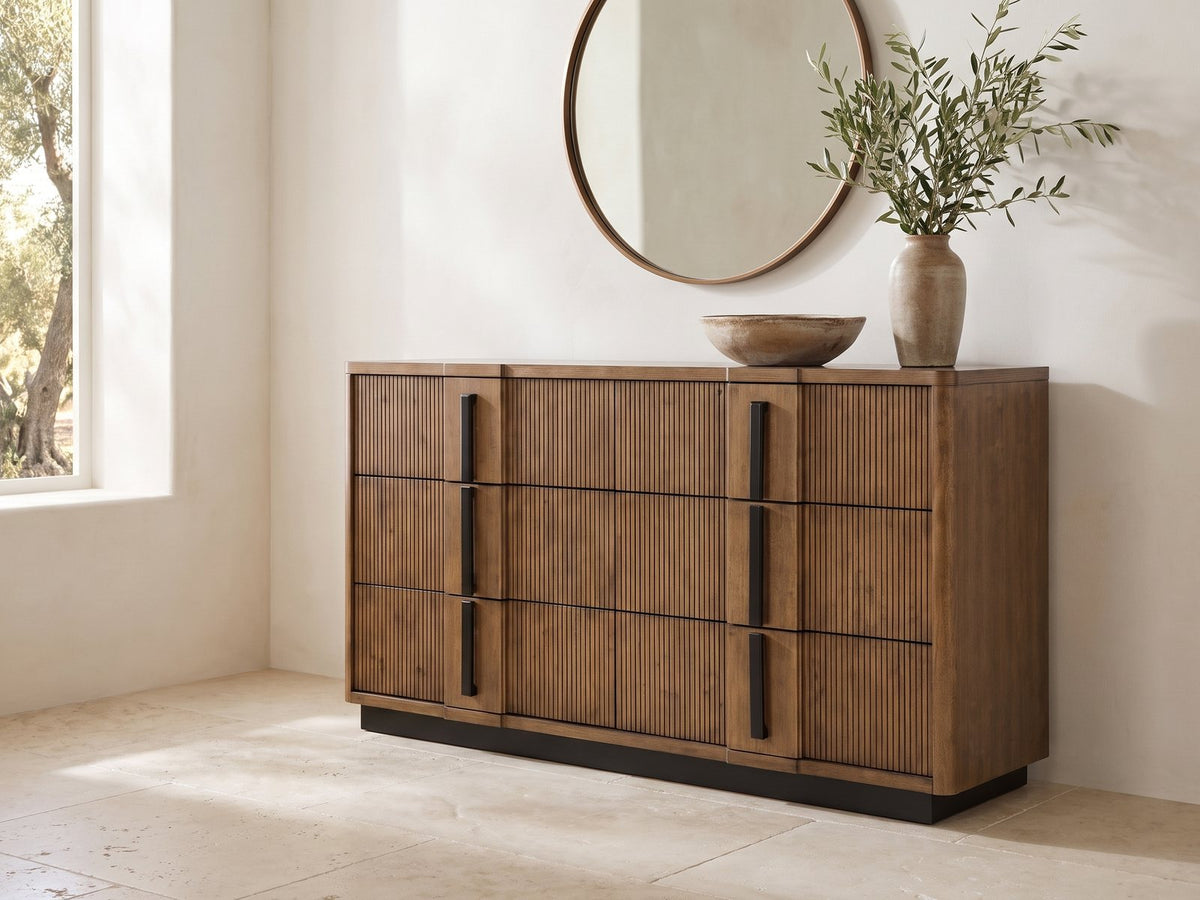 Castelfranco 65.5-Inch Ash Brown Reeded 6-Drawer Dresser under a round bronze mirror in a villa bedroom