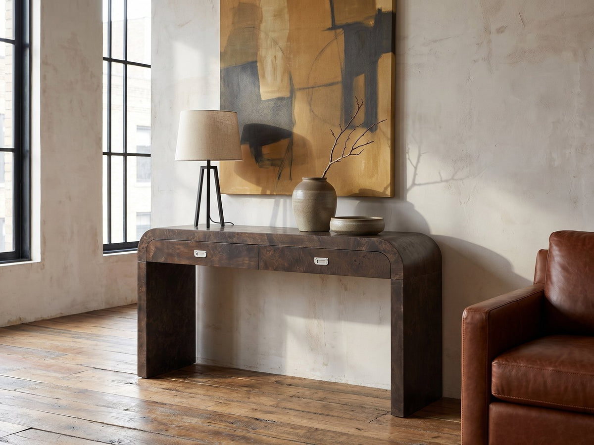 Castellana Burl Veneer Waterfall Console Table against a plaster wall in an industrial loft
