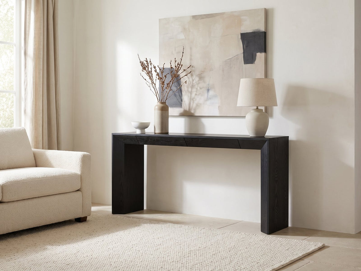 Cellamare Black Ash Veneer Waterfall Console Table against a plaster wall under an abstract canvas in a bright living room