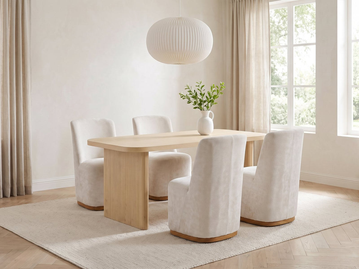 Cetraro 68.75-Inch Fluted Leg Dining Set with 4 Upholstered Chairs in a bright plaster dining room with linen curtains