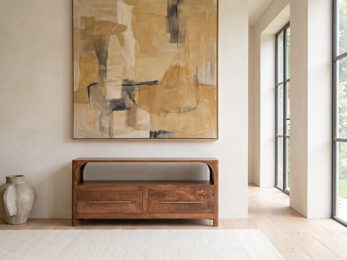 Cherasco Arch Mango Media Console under a large abstract painting in a bright living room
